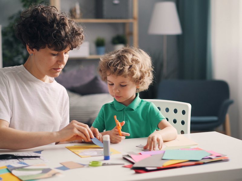 A parent and child talking at a table at home
